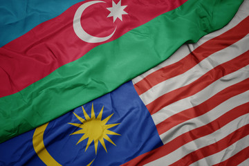 waving colorful flag of malaysia and national flag of azerbaijan.