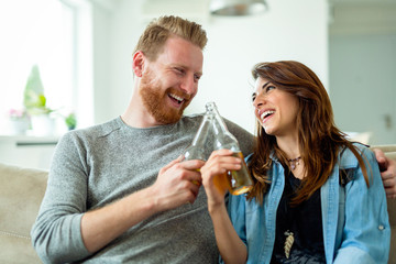 Young couple drinking and celebrating together at home