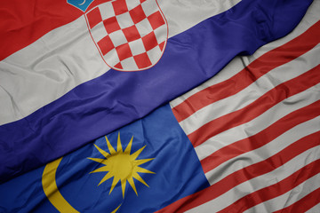 Obraz premium waving colorful flag of malaysia and national flag of croatia.