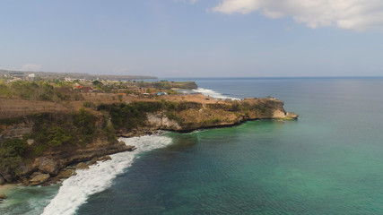 Fototapeta na wymiar Aerial view rocky seashore with sandy beach. seascape ocean surf and tropical beach large waves turquoise water crushing on beach Bali,Indonesia. Travel concept.
