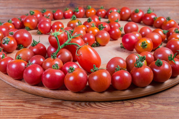 Cherry tomatoes on the wooden serving board close-up