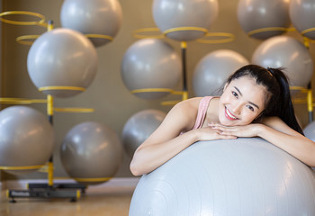 Naklejka premium The girl sitting relax with the ball in the gym.