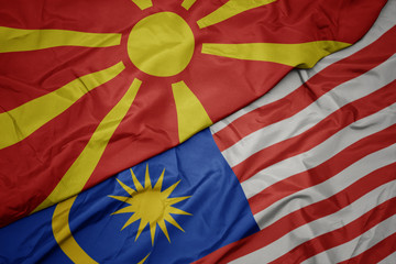 waving colorful flag of malaysia and national flag of macedonia.