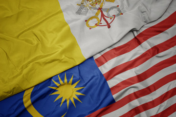 waving colorful flag of malaysia and national flag of vatican city.