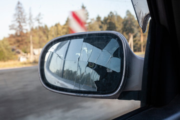 Broken rear view mirror on a car. Vandalism of teenagers breaking glass in cars. How to go if the road is not visible. Car with a broken part.