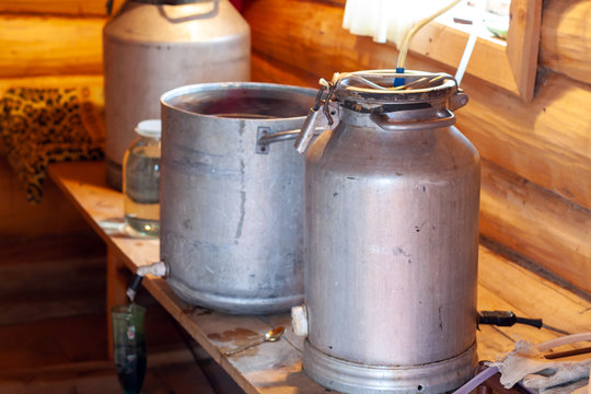 The process of preparing moonshine in a village bath in a primitive moonshine distilling-apparatus.