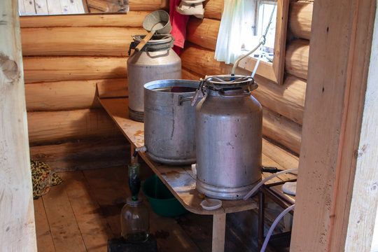 The process of preparing moonshine in a village bath in a primitive moonshine distilling-apparatus. Moonshine. Manufacture of moonshine in Russia.
