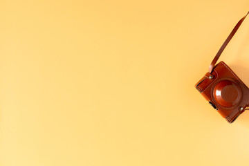 Summer modern minimal composition. Photo camera on pastel yellow background. Travel concept. Flat lay, top view, copy space