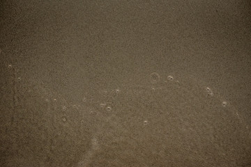 Onde sulla sabbia in spiaggia d'estate