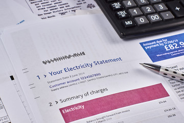 Electricity statement sheet with calculator and pen. Close-up