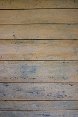 Texture of an old wooden wall of boards with peeling beige paint