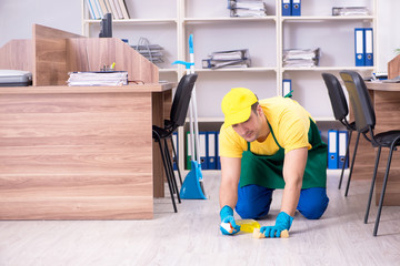 Young male contractor cleaning the office