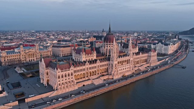 Fly around the top of the Parliament building in Budapest in the evening at sunset against the background of the Danube River