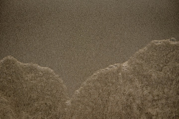Onde sulla sabbia in spiaggia d'estate