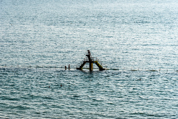 People jumping from the trampoline in swimming pool at the beach of Saint Malo