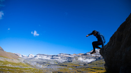 mountain runner jumping over a precipice in the Pyrenees of Spain