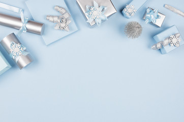 Ideas for design christmas decorations - soft light pastel blue and silver metallic wrapping for gifts and glitter christmas tree with copy space, top view.