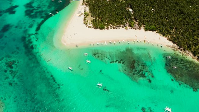 Tropical island in the ocean with palm trees on white sand beach. Daco island, Philippines. Summer and travel vacation concept