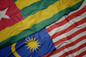waving colorful flag of malaysia and national flag of togo.