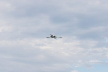 Military bomber aircraft flying in the cloudy sky in daylight