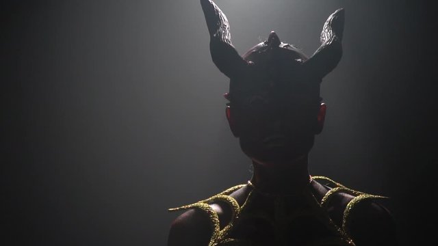 Silhouette of a creepy female demon with massive horns on her head