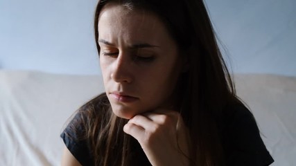 Close up desperate woman sit on sofa looking away feel depressed doubtful, lonely stressed upset young  girl thinking of psychological problem thinking regret about mistake
