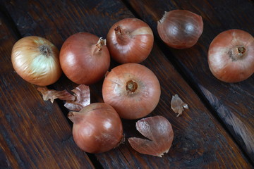Several ripe onions isolated on a dark wooden background. Concept vitamins, healthy food