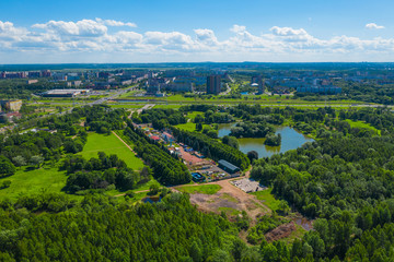 Obraz premium Aerial view of South Seaside Park on southwest part of St. Petersburg city. Summer, a lot of green trees, attraction park, blue sky. Russia