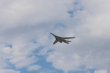 Naklejka na ściany i meble Military bomber aircraft flying in the cloudy sky