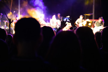 El público graba su teléfono inteligente un concierto musical por la noche