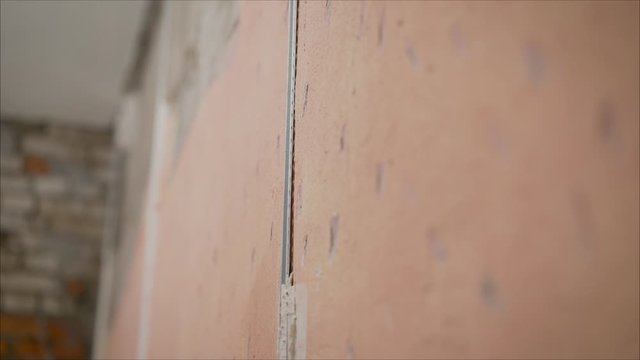 Plastering walls and lighthouses. Applying aluminum, the water level of the brick wall to check the flatness of the plane