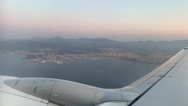 Beautiful aerial shot from the airplane window with view to the pier harbor of Palma de Mallorca Spain during the sunset at the horizon. 4 Wide shot.