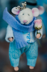 toy mouse in clothes handmade wool in the hands of a rose, a crown on his head, selective focus