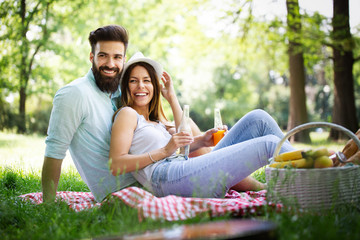 Beautiful young couple enjoying in a good mood and picnic day