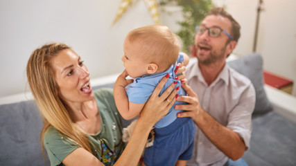 Parents playing with a baby at home.