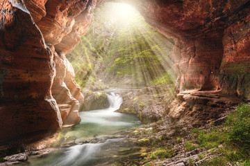 Idyllische Landschaft mit Wasserfall und Höhle