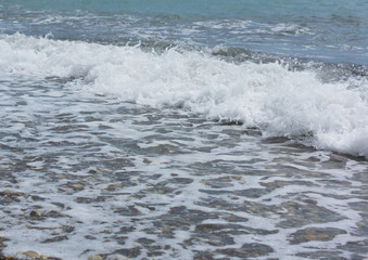 Fototapeta premium The wave rolls on the rocky shore.