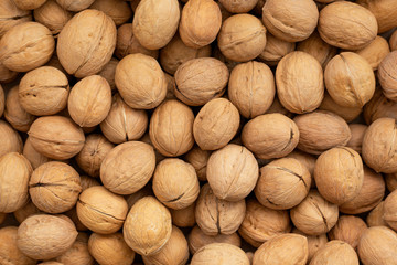 Background of fresh walnuts, scattered pile of walnuts. Top view. 