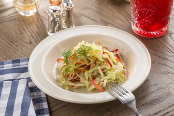 Fresh organic lettuce salad with cucumber, tomatoes and bell pepper and glass of red drink on wooden table