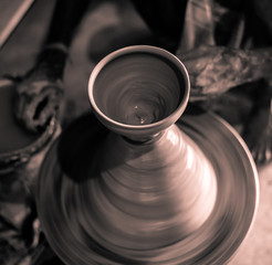 Image of Unfinished Clay pot with Pottery wheel spinning . Selective Focus is used.