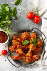 Tasty snack. Baked chicken wings with mustard tomato sauce on a concrete table. Top view flat lay.