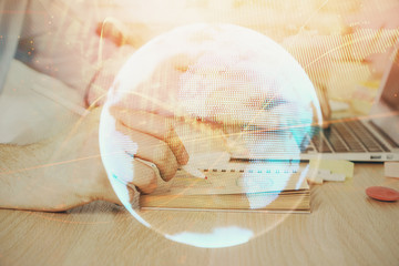 Multi exposure of businessman working on laptop on background. International business hologram in...