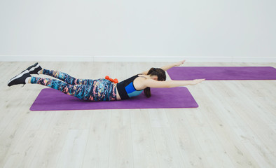 Sporting woman practicing the cobra pose during their yoga class in a gym