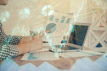 Double exposure of financial graph with man works in office on background. Concept of analysis.