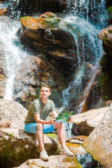 Man enjoying view of waterfall in gungle
