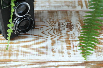 Black retro medium format dual-lens SLR film camera on wooden background of white boards with...