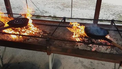 Pair of pans over the fire where chestnuts are cooked, Vittorio Veneto, Italy
