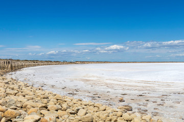 Camargue white salt flat lake, etang salt water lagoon surrounded by sand dunes, Southern France