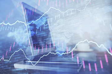 Stock market graph on background with desk and personal computer. Double exposure. Concept of financial analysis.