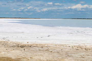 Camargue white salt flat lake, etang salt water lagoon surrounded by sand dunes, Southern France